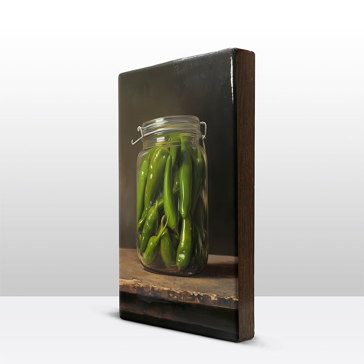 121. Groene pepers in een glazen pot op houten paneel(tje) klein